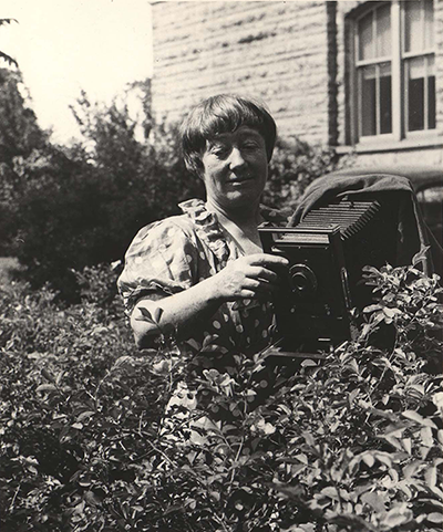 Black and white image of Ada Hayden with camera