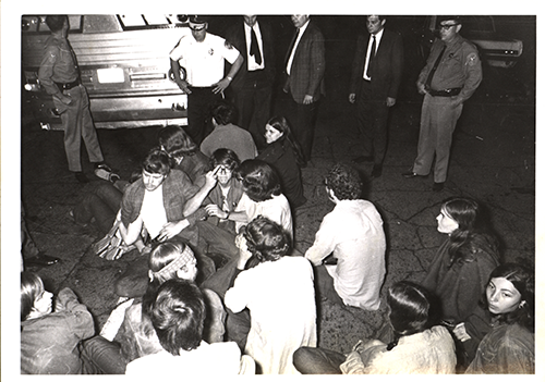 Image of anti-war protesters sitting in the street and blocking traffic