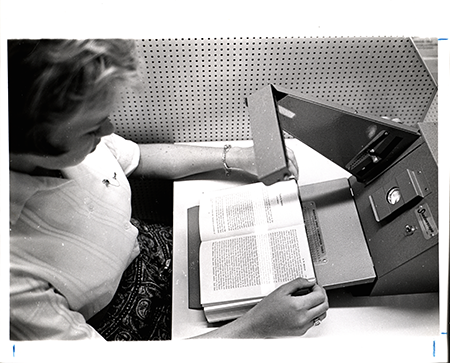 Image of a young woman demonstrating a reading machine, viewed from above